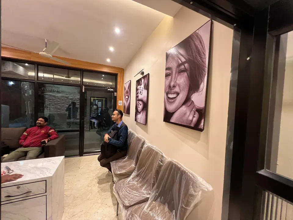More black-and-white patient smile portraits displayed in the reception area
