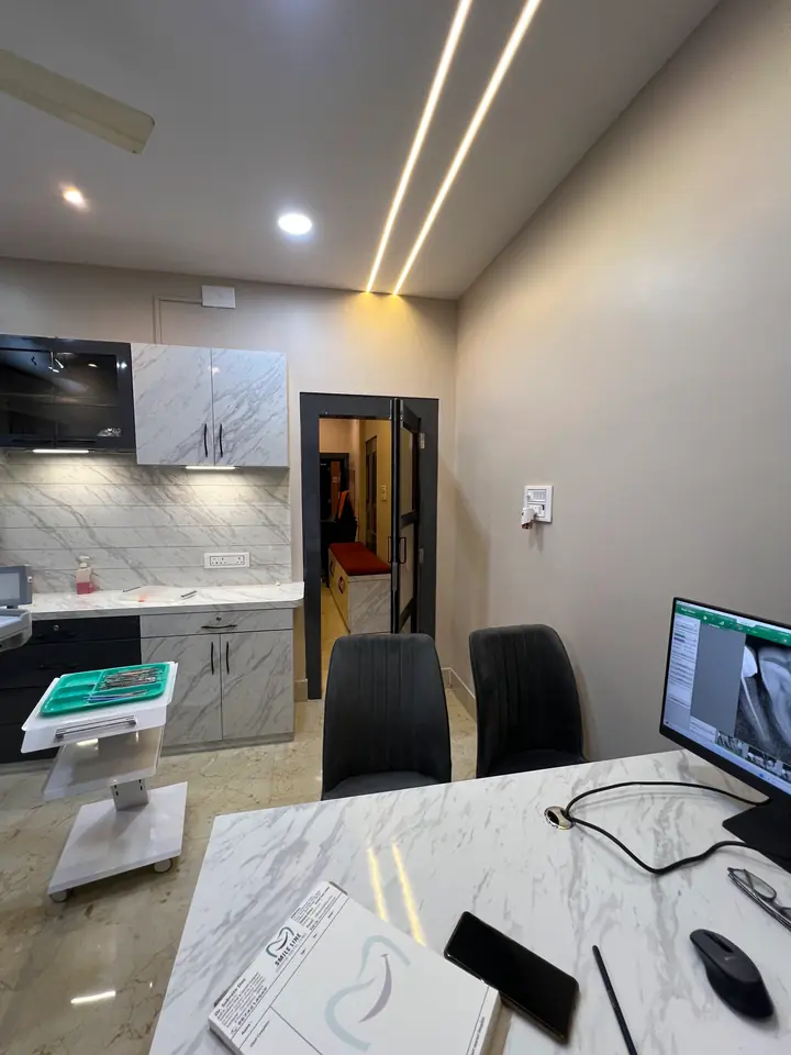 A dentist at Smile Line reviewing a patient's digital X-ray on a monitor